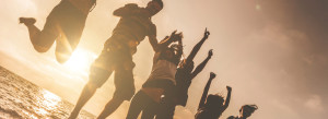 kids jumping in the air by the water